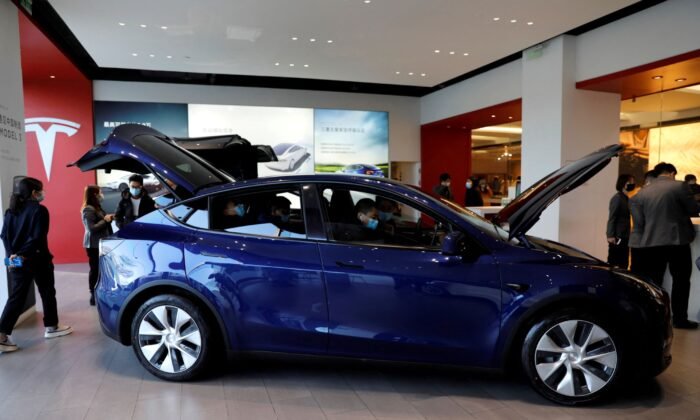 Visitors check a Tesla Model Y sport utility vehicle (SUV) at the electric vehicle maker's showroom in Beijing, China, on Jan. 5, 2021. (Tingshu Wang/Reuters)